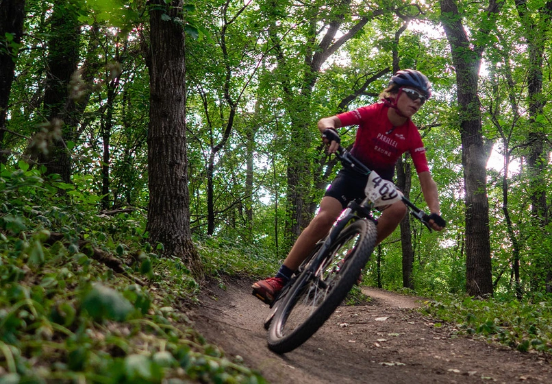 Person biking in the woods on a trail