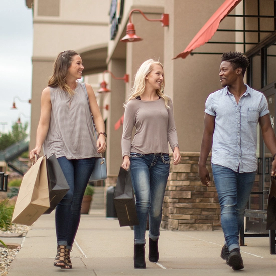 Three people walking outside a mall