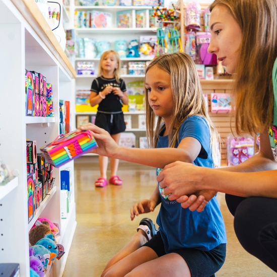 A mom and her two children looking at toys at Child's Play Toys
