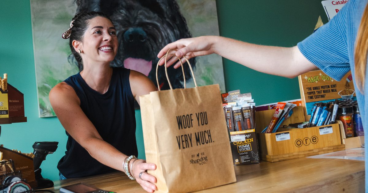 Woman giving another her bag with her purchases