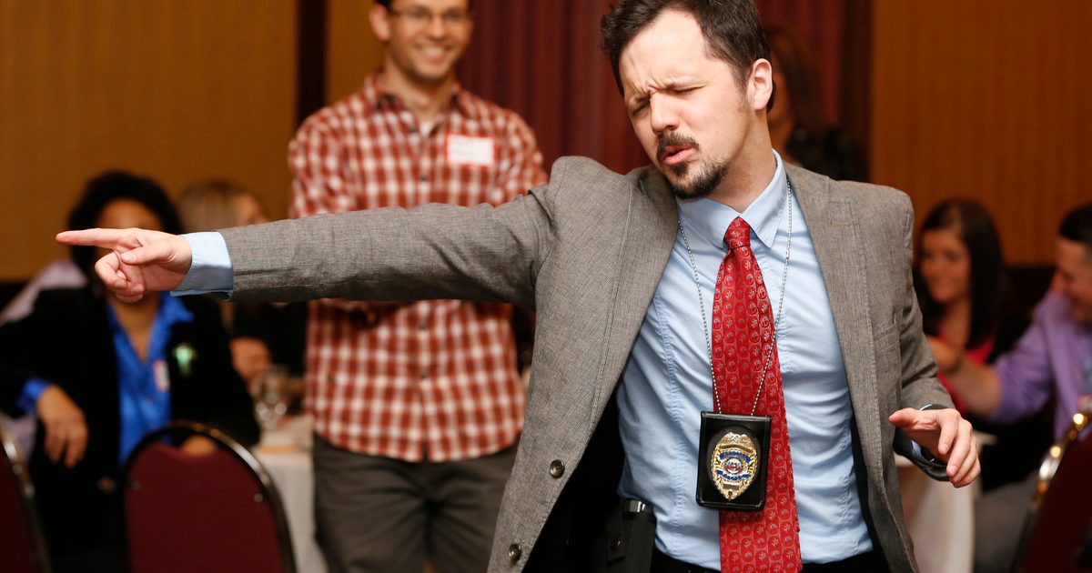 Nick Rowley, playing the role of detective Richard Less, gets excited over clues March 28, 2014 during The Dinner Detective event at the Embassy Suites in Des Moines.
